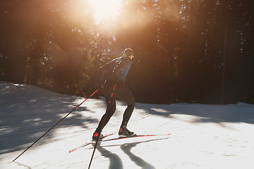 Image showing Nordic skiing or Cross-country skiing classic technique practiced by man in a beautiful panoramic trail at morning.