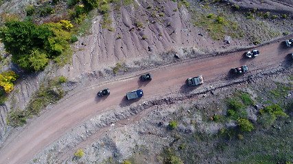 Image showing Aerial drone view of ATV quads on a dirt trail in forests. Off-road group team club enthusiasts having fun while driving countryside roads.