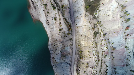 Image showing Turquoise water in a mountain forest lake with pine trees. Aerial view of blue lake and green forests. View on the lake between mountain forest. Over crystal clear mountain lake water. Fresh water