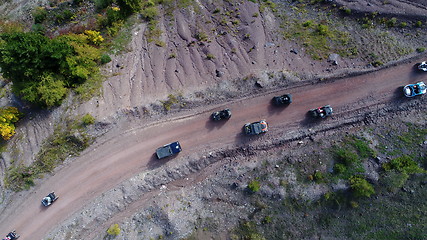 Image showing Aerial drone view of ATV quads on a dirt trail in forests. Off-road group team club enthusiasts having fun while driving countryside roads.