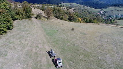 Image showing Aerial drone view of ATV quads on a dirt trail in forests. Off-road group team club enthusiasts having fun while driving countryside roads.