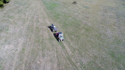 Image showing Aerial drone view of ATV quads on a dirt trail in forests. Off-road group team club enthusiasts having fun while driving countryside roads.