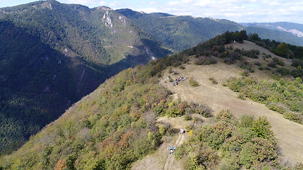 Image showing Aerial drone view of ATV quads on a dirt trail in forests. Off-road group team club enthusiasts having fun while driving countryside roads.