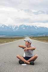 Image showing Young boy sitting on the road