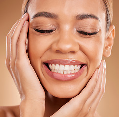 Image showing Smile, self love and hands on face of woman in studio for makeup, skincare and cosmetics on brown background. Closeup, beauty and happy girl model relax with natural and glowing skin while isolated