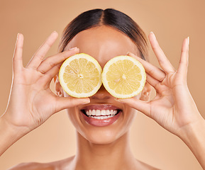 Image showing Lemon on eyes, skincare and face of woman with smile in studio for wellness, facial treatment and natural cosmetics. Beauty, spa and happy girl with fruit slice for detox, vitamin c and dermatology