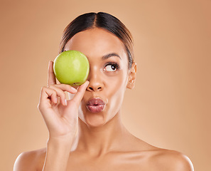 Image showing Beauty, skincare or woman with apple in studio on beige background for healthy nutrition or clean diet. Eye, hand or girl model advertising or marketing natural fruits for nutrition or wellness