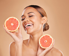 Image showing Skincare, grapefruit and face of woman with laugh in studio for wellness, facial treatment and natural cosmetics. Beauty, spa aesthetic and happy girl with fruit for detox, vitamin c and dermatology