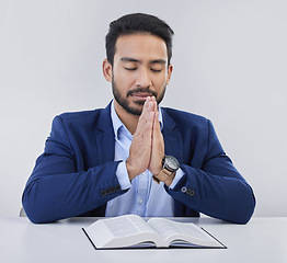 Image showing Mockup, faith and Asian man, praying, bible and guidance against grey studio background. Japanese male, believer and Christian guy with holy book, prayer and hope for solution, religious or gratitude