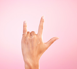 Image showing Sign language, funky and hand with a gesture for rock isolated on a pink background in a studio. Celebrate, deaf communication and person gesturing for metal music, emoji and expression on a backdrop