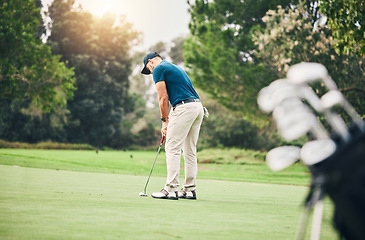 Image showing Man, golf ball and putter on grass to ready for game, sport and aim shot in competition with focus outdoor. Professional golfer, start and put shooting for contest on field, lawn and course in summer
