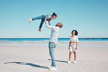 Image showing Playing, happy and child with parents at the beach for bonding, quality time and relaxation. Smile, family and playful girl kid with dad and mother at the ocean for holiday, happiness and summer