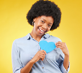 Image showing Happy, paper and heart with portrait of black woman in studio for support, kindness and romance. Smile, love and emotion with female isolated on yellow background for date, feelings and happiness