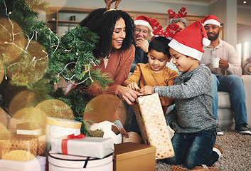 Image showing Christmas, family and boys opening a gift, celebrating a holiday and happy with a box. Smile, giving and excited children starting to open a present from their mother during festive season together