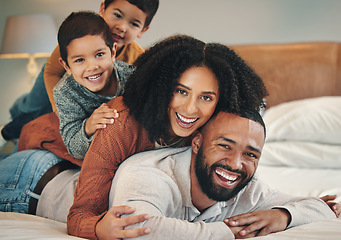 Image showing Family, laughing and portrait smile on bed in bedroom, bonding and care in home. Love, interracial and happy mother, comic father and funny children playing, having fun and enjoying time together.