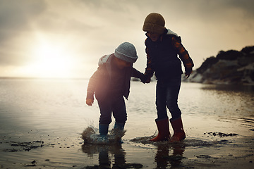 Image showing Sunset, silhouette and friends on beach, playing and bonding on summer vacation, break and happiness. Dusk, young people and kids on seaside holiday, brothers and ocean with children, joy or cheerful