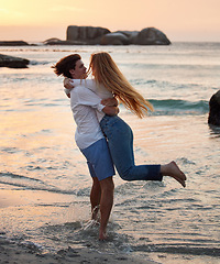 Image showing Couple in ocean, freedom and hug, love and commitment in relationship, man swing woman with adventure at beach. Trust, partnership and care with people outdoor, romance and happiness at sunset