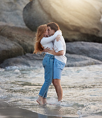 Image showing Love, kiss and happy with couple at beach for romance, relax and vacation trip. Travel, sweet and cute relationship with man and woman kissing on date for summer break, affectionate and bonding