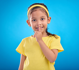 Image showing Young girl secret, portrait and studio with a student feeling happy with blue background. Isolated, cute and adorable child face in a yellow outfit with happiness, whisper and cheerful from gossip