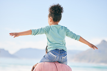 Image showing Beach, black man with child on shoulders from back on playful family holiday in Australia with freedom and fun. Travel, fun and happy father and girl playing, flying and bonding together on vacation.