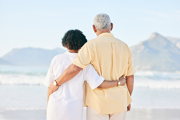 Image showing Senior couple at beach, hug and travel, retirement and love outdoor, vacation with ocean view and relax in nature. Peace, zen and tropical island, man and woman watching sea waves, back and wellness