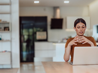 Image showing Woman sitting in living room using laptop look at cam talk by video call with business friend relatives, head shot. Job interview answering questions.