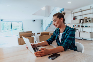 Image showing Woman sitting in living room using laptop look at cam talk by video call with business friend relatives, head shot. Job interview answering questions.