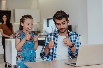 Image showing Father and daughter in modern house talking together on laptop with their family during holidays. The life of a modern family