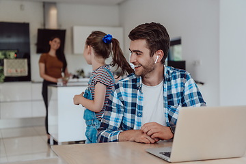 Image showing Father and daughter in modern house talking together on laptop with their family during holidays. The life of a modern family