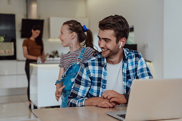 Image showing Father and daughter in modern house talking together on laptop with their family during holidays. The life of a modern family