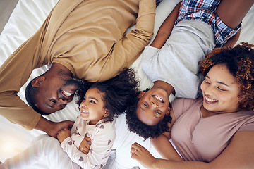 Image showing Above, happy and black family laughing in bed, smile and bonding while resting in a home with care. Top view, relax and children waking up with mother and father in a bedroom, playful and having fun