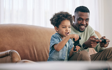 Image showing Black family, dad and child playing video games on living room sofa together with controllers at home. Happy African American father with son with smile enjoying bonding time on console entertainment