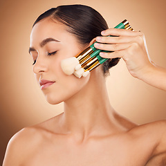 Image showing Beauty, cosmetics and makeup, woman with brushes on face, aesthetic brown background and studio profile. Skincare, facial transformation and luxury cosmetic product for glowing skin on elegant model.