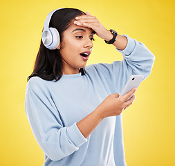 Image showing Shock, surprise and woman with phone, headphones and hand on head isolated on yellow background. Social media, music news or exciting online gossip, hispanic girl reading notification on smartphone.