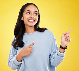 Image showing Yellow background, point and face of woman with smile for advertising, promotion and announcement. Mockup space, studio and isolated happy girl with hand gesture for information, discount or news