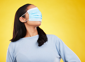 Image showing Covid, face mask and blindfold with woman in studio for medical, crazy and healthcare. Comic, virus and carefree with female on yellow background for vaccine, protection and pandemic safety