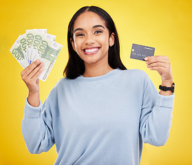 Image showing Woman, portrait smile and credit card with money for ecommerce, shopping or banking against a yellow studio background. Happy female shopper smiling and holding cash and debit from bank withdrawal