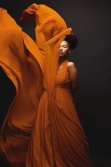 Image showing Black woman, wind and art in fashion, fabric on dark background and motion in aesthetic movement. Flowing silk, fantasy and artistic beauty, sensual African model in creative designer dress in studio
