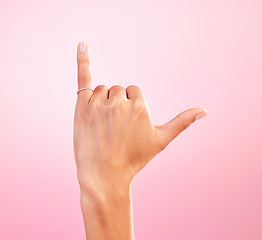 Image showing Woman hand, shaka and studio with a icon, emoji and hang ten surfing sign. Isolated, pink background and female hands showing winner, surf and motivation signal with mockup and winning gesture