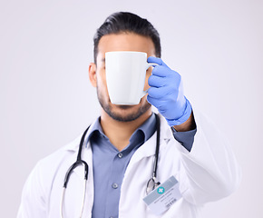 Image showing Hand, coffee and break with doctor man in studio on a gray background for a drink to start his morning. Medical, healthcare and beverage with a medicine professional holding a cup or mug for tea