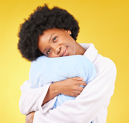 Image showing Sleepy, tired and a black woman hugging a pillow on a yellow background in studio at bed time. Relax, wake up and comfort with an attractive young female holding a cushion in the morning after rest