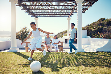 Image showing Family, vacation and children playing soccer on a lawn in a holiday house and girl kick a ball having fun outdoors. Happy, excited and grandparents watch kids on the grass to play football