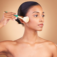 Image showing Makeup, product and brush with indian woman in studio for foundation, blush and self care. Glow, cosmetics and facial with female model isolated on brown background for shine, clean and confidence