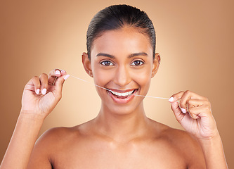 Image showing Floss, studio and portrait of a woman with healthcare, cleaning and dental health. Isolated, brown background and young female model with happiness from clean teeth and mouth wellness with a smile