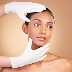 Image showing Beauty, plastic surgery and hands with face of Indian woman in studio for cosmetics and skincare. Spa treatment, dermatology and beautician with female on brown background for consulting