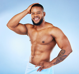 Image showing Towel, shower and fitness portrait of a black man with happiness from bodybuilder muscle. Cleaning, skincare and wellness after workout and exercise with isolated, studio and blue background