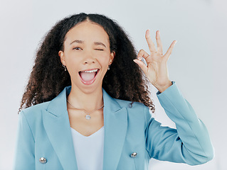 Image showing Business woman, okay sign and wink emoji in studio for agreement, support and success. Face portrait of female person with hand gesture for thank you, perfect or approval isolated on white background