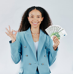 Image showing Portrait, happy and cash with a business woman in studio on a gray background making a perfect hand gesture. Face, finance and money with a female employee holding euro bills for investment