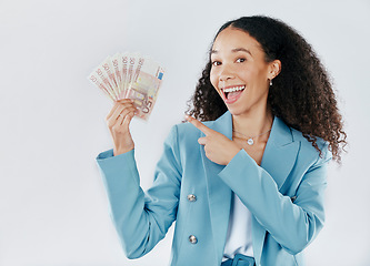 Image showing Portrait, pointing and cash with a business woman in studio on a gray background for financial freedom. Smile, finance and money with a happy female employee holding euro bills for investment