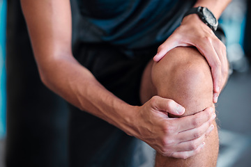 Image showing Hands, knee and injury with a sports man holding his joint in pain while training in a gym for health. Fitness, accident and anatomy with a male athlete suffering from an injured body during exercise